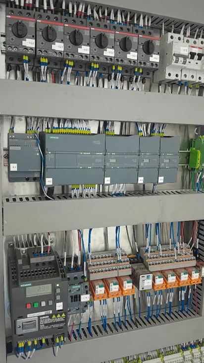 Gabinete de control abierto con PLC y cableado industrial fabricado por SEEA